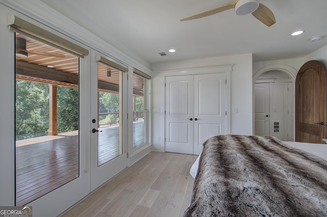 unfurnished bedroom featuring a closet, ceiling fan, access to exterior, french doors, and light wood-type flooring