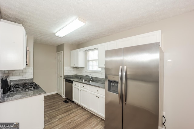 kitchen featuring hardwood / wood-style floors, sink, a textured ceiling, appliances with stainless steel finishes, and white cabinetry