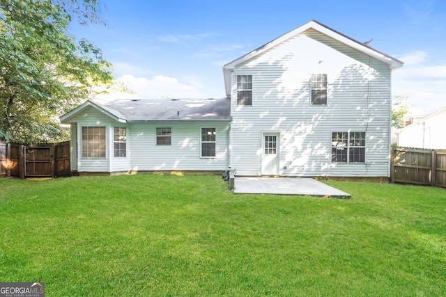 back of house with a yard and a patio