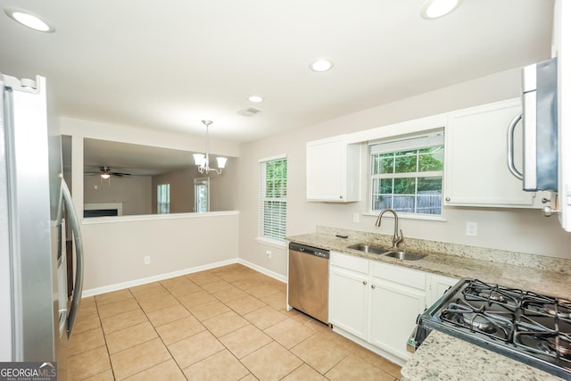 kitchen with ceiling fan with notable chandelier, sink, appliances with stainless steel finishes, decorative light fixtures, and white cabinetry