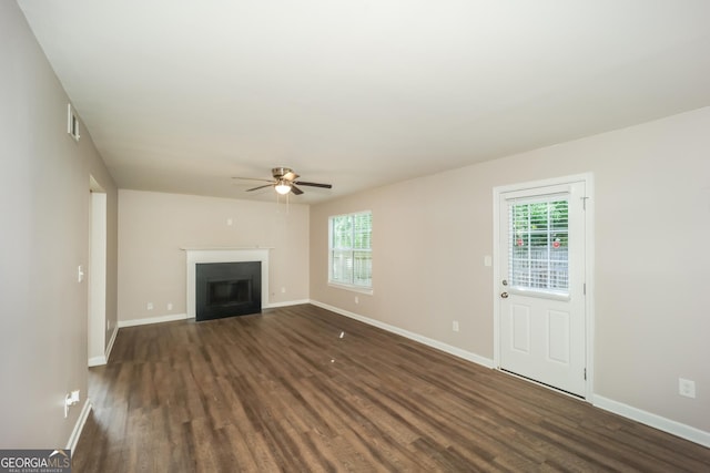 unfurnished living room with ceiling fan and dark wood-type flooring