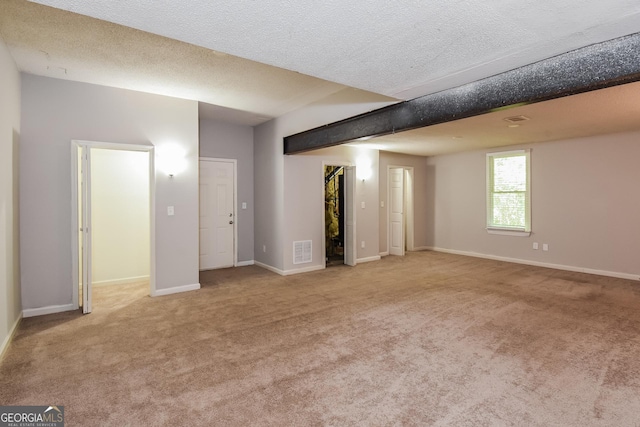 spare room with light carpet and a textured ceiling