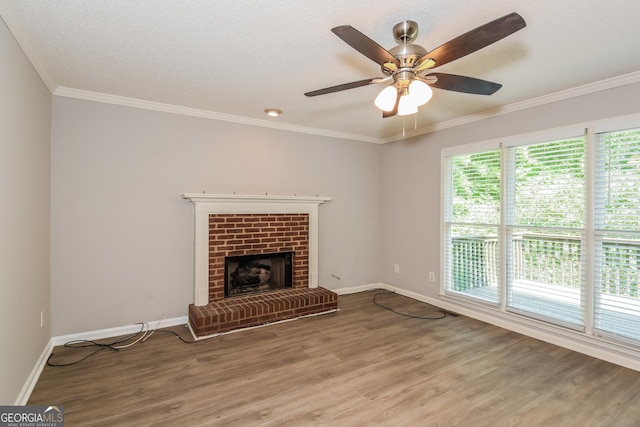 unfurnished living room with ornamental molding, a textured ceiling, ceiling fan, wood-type flooring, and a fireplace