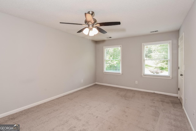 carpeted empty room featuring a textured ceiling and ceiling fan