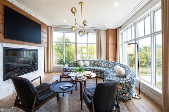 sunroom featuring a tile fireplace and a notable chandelier