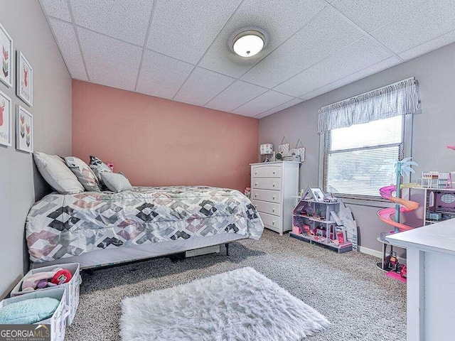 carpeted bedroom with a paneled ceiling