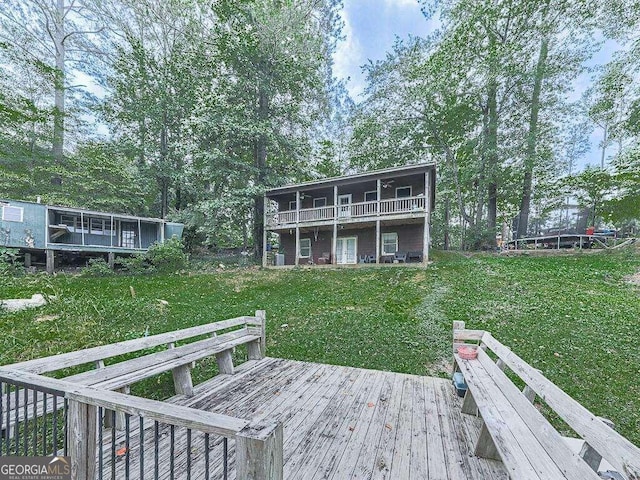 back of house with a deck and a lawn