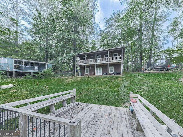 rear view of property featuring a yard and a deck