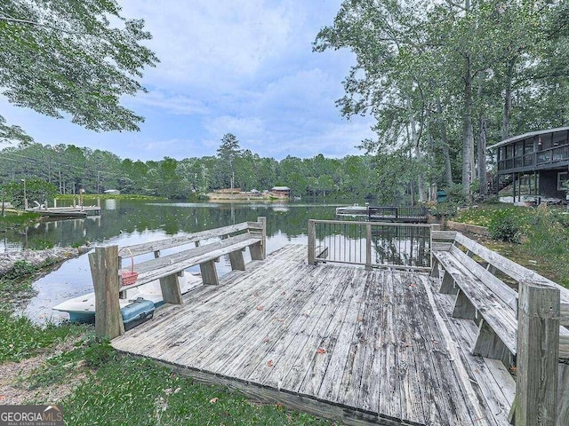 view of dock featuring a water view and a wooded view