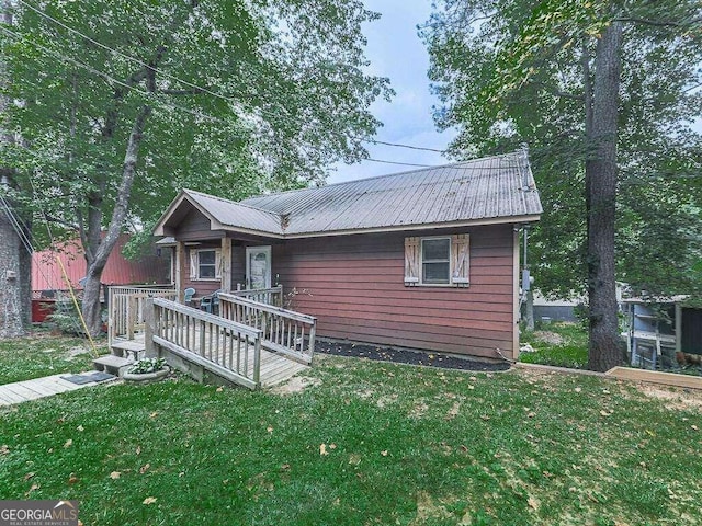 view of front facade with a wooden deck and a front yard