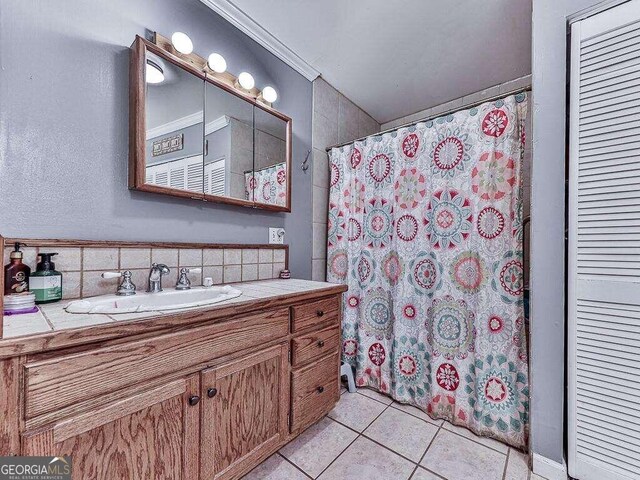 bathroom with tasteful backsplash, a shower with shower curtain, tile patterned flooring, and vanity