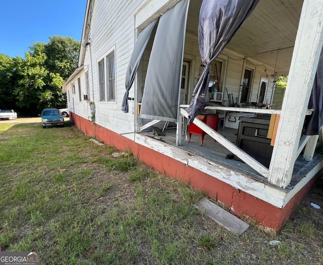 view of side of home featuring a yard and a porch