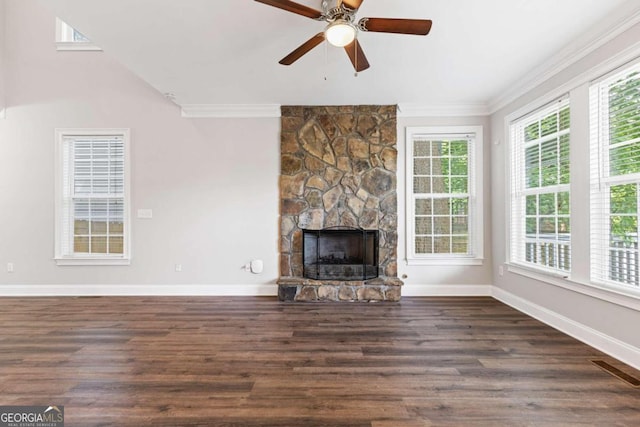 unfurnished living room featuring a stone fireplace, ceiling fan, dark hardwood / wood-style flooring, and ornamental molding