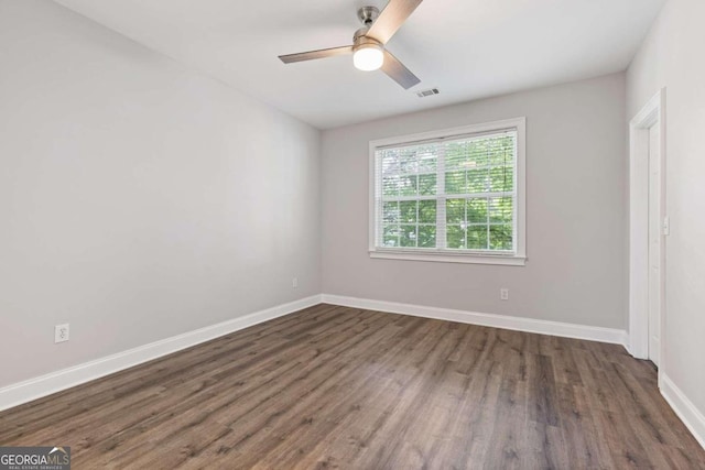 spare room featuring ceiling fan and dark wood-type flooring