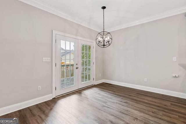 unfurnished dining area with dark hardwood / wood-style flooring, crown molding, french doors, and an inviting chandelier