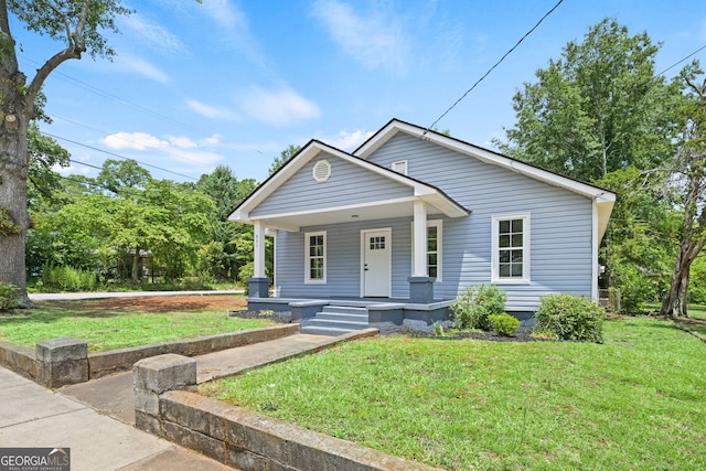 bungalow-style home with covered porch and a front lawn