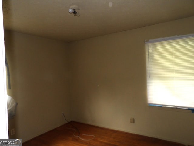 unfurnished room with dark hardwood / wood-style flooring