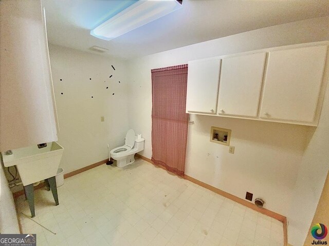 clothes washing area featuring light tile patterned floors, hookup for a washing machine, and cabinets