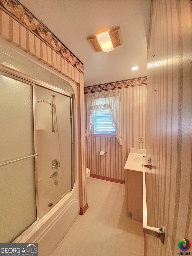 full bathroom featuring combined bath / shower with glass door, toilet, tile patterned flooring, and vanity