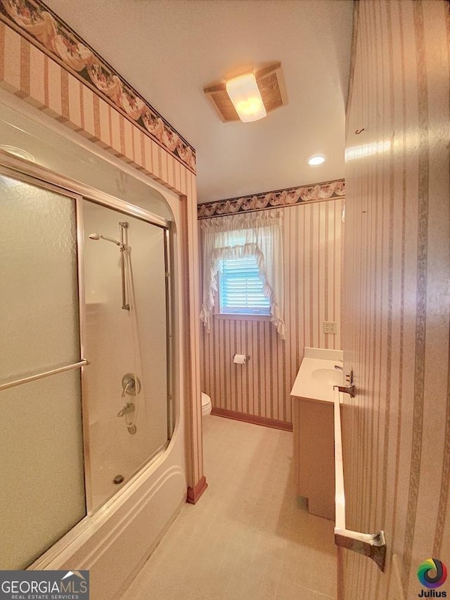 full bathroom with toilet, visible vents, vanity, combined bath / shower with glass door, and wallpapered walls