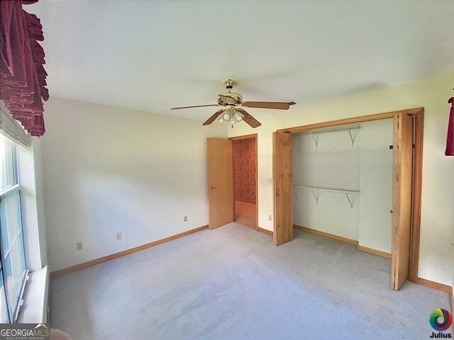 unfurnished bedroom featuring ceiling fan, light carpet, and a closet