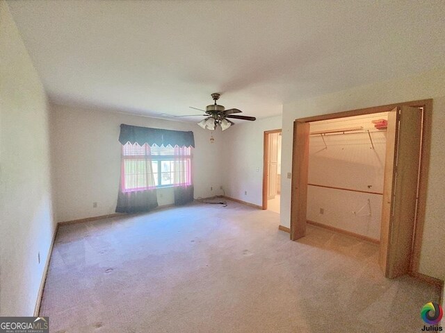 unfurnished bedroom with light colored carpet, a closet, and ceiling fan