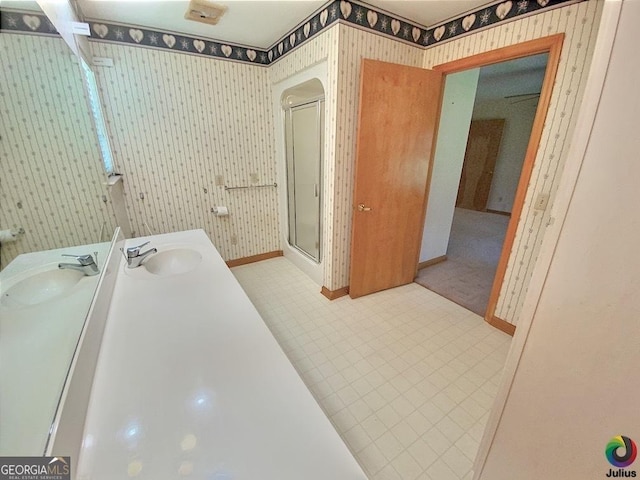 bathroom with wallpapered walls, baseboards, tile patterned floors, vanity, and a shower stall