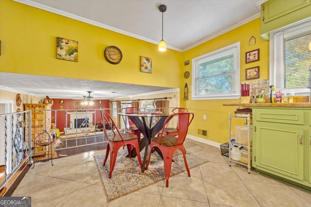 dining space featuring light tile patterned flooring, crown molding, and ceiling fan