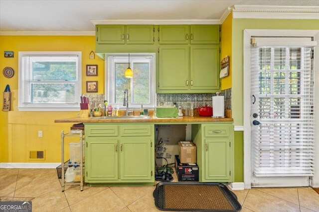 kitchen featuring light tile patterned flooring, green cabinetry, tasteful backsplash, and sink