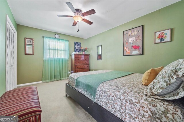 carpeted bedroom featuring a closet and ceiling fan