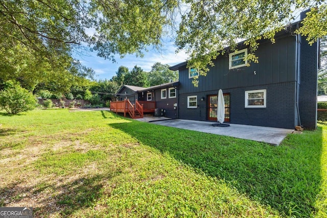 back of property with a patio area and a lawn