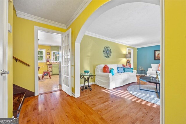 interior space featuring crown molding, a textured ceiling, hardwood / wood-style flooring, and french doors