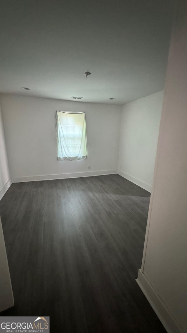 spare room with dark hardwood / wood-style floors