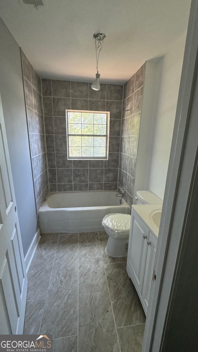 full bathroom with vanity, tiled shower / bath combo, and toilet