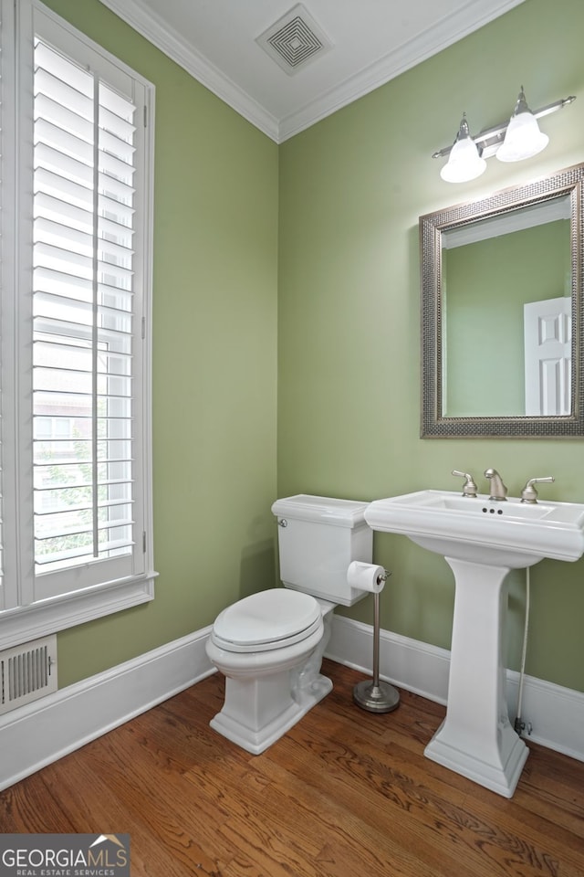 bathroom featuring crown molding, sink, wood-type flooring, and toilet