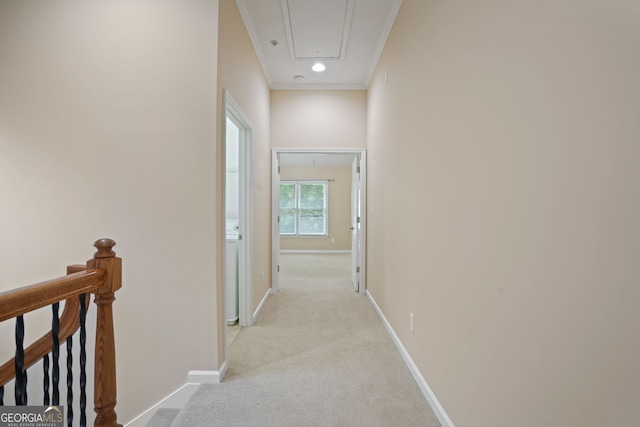 hallway with ornamental molding and light colored carpet