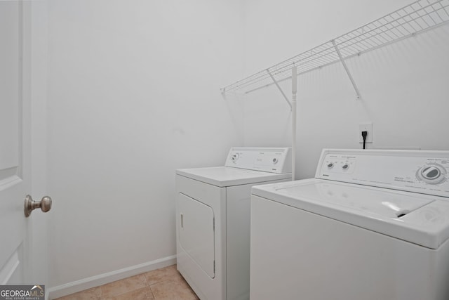 laundry area featuring washing machine and dryer and light tile patterned flooring