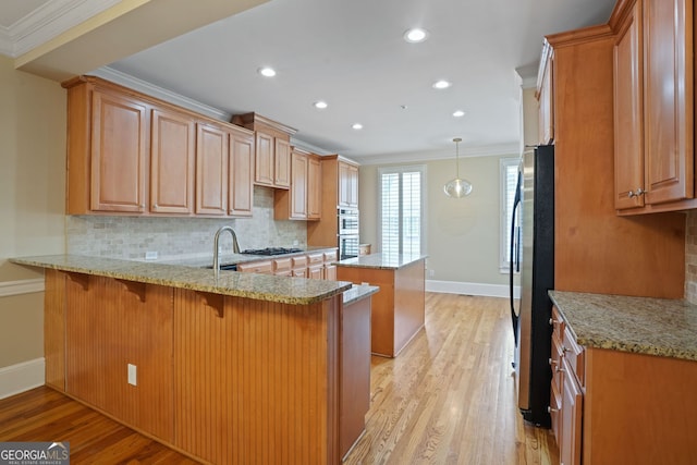 kitchen with backsplash, light hardwood / wood-style flooring, and kitchen peninsula