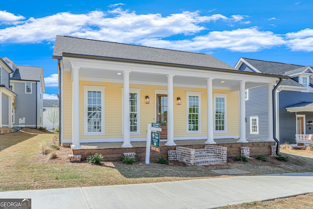 view of front facade featuring a porch and roof with shingles