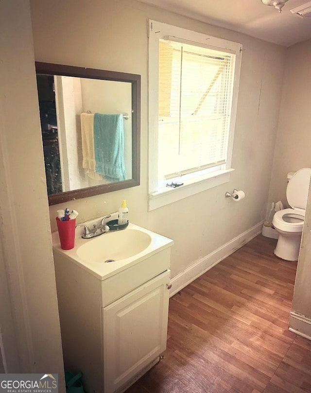 bathroom featuring hardwood / wood-style flooring, vanity, and toilet