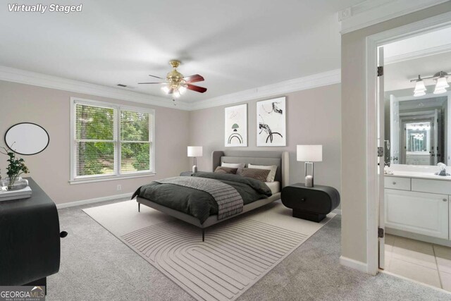 bedroom featuring light carpet, connected bathroom, crown molding, and ceiling fan