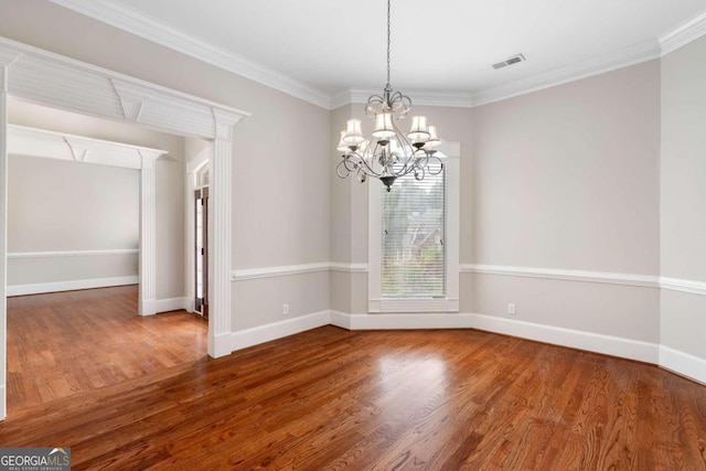 unfurnished room featuring an inviting chandelier, dark wood-type flooring, and crown molding