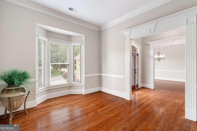 interior space featuring an inviting chandelier, ornamental molding, and hardwood / wood-style floors