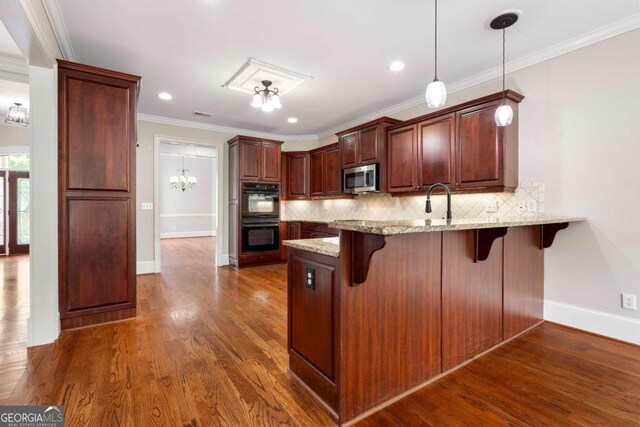 kitchen with a breakfast bar, double oven, backsplash, and dark hardwood / wood-style floors