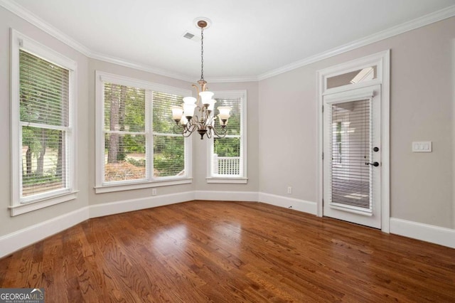 unfurnished dining area featuring crown molding, dark hardwood / wood-style floors, and a notable chandelier