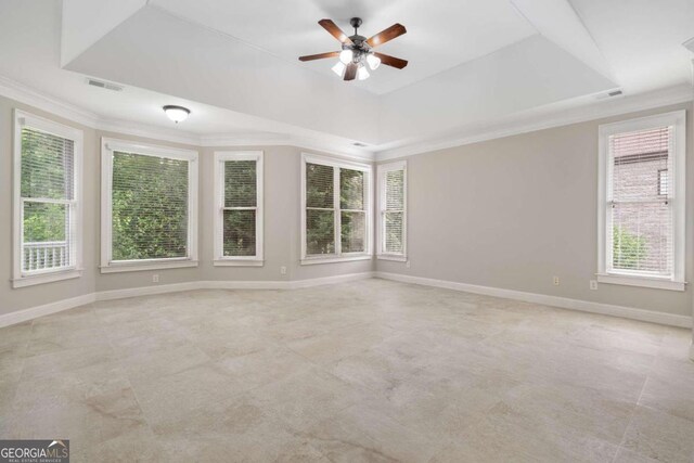 unfurnished room featuring ceiling fan, crown molding, a tray ceiling, and light tile patterned floors