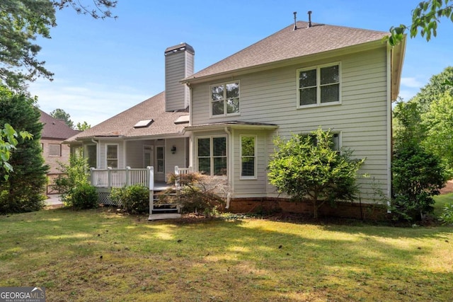 back of property with a deck and a lawn