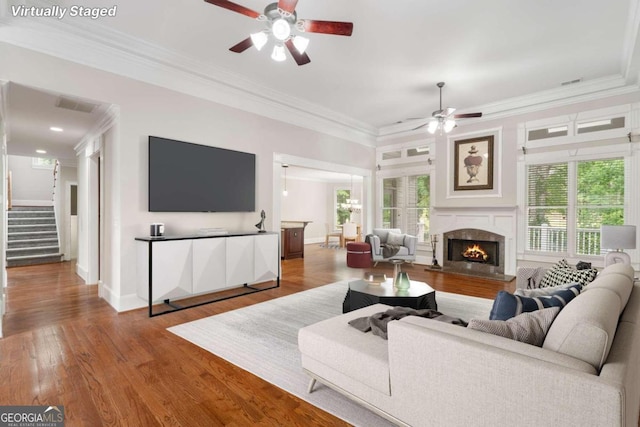 living room featuring a wealth of natural light, ceiling fan, hardwood / wood-style floors, and a high end fireplace