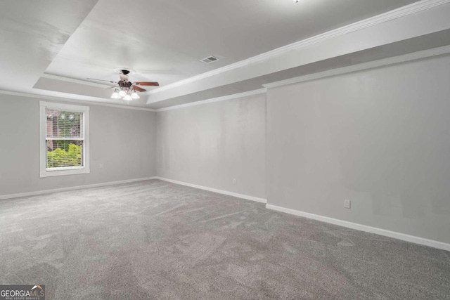 spare room featuring crown molding, carpet, ceiling fan, and a raised ceiling