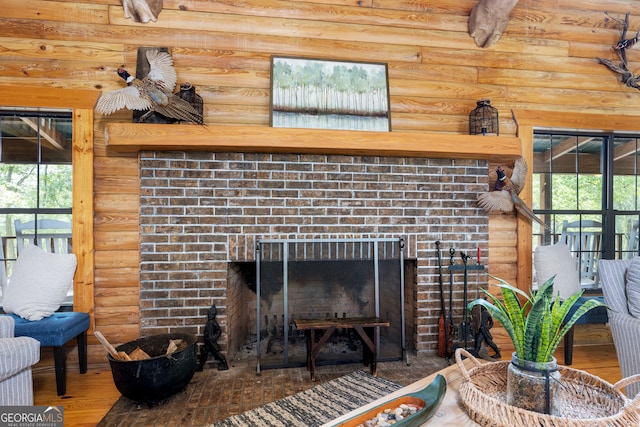 living room featuring a fireplace, plenty of natural light, hardwood / wood-style floors, and rustic walls